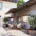 Tenda da sole BT R97 Stone su una terrazza con tavolo e ulivi